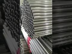 A large number of neatly stacked stainless steel pipes